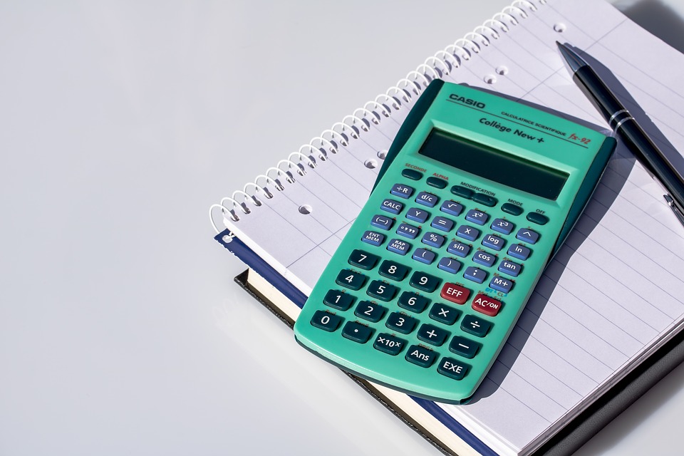 calculatrice posée sur cahier avec stylo